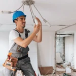 Electrician installing energy-efficient LED bulbs in a ceiling fixture